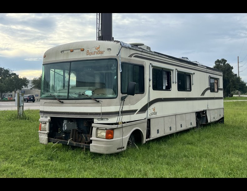 A beat-up old Bounder motorhome at the side of the road