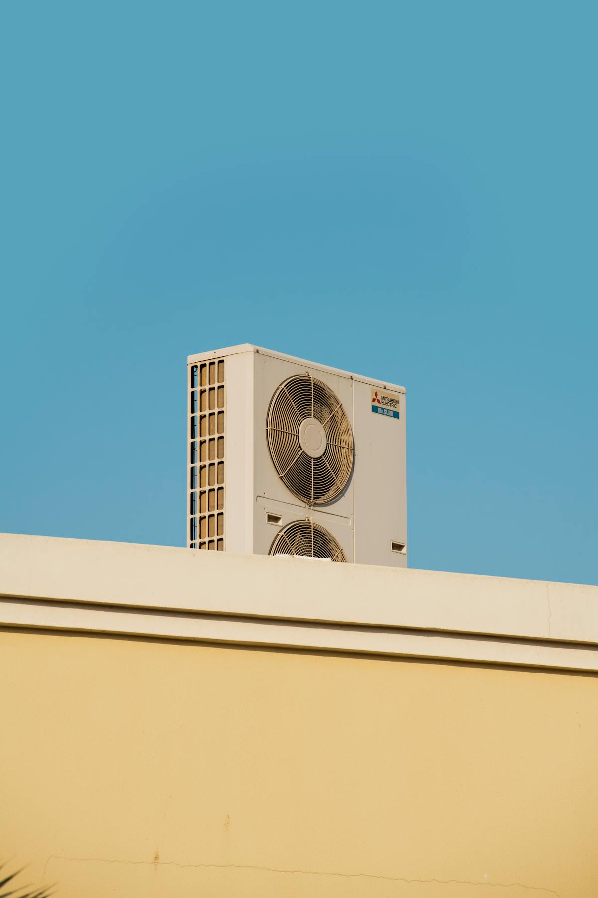 A rooftop AC unit against a blue sky.
