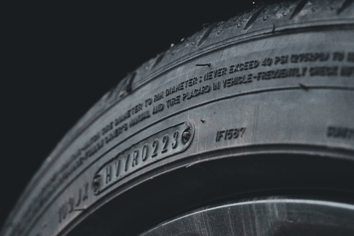 A close-up of a black tire showing sidewall text and treads.