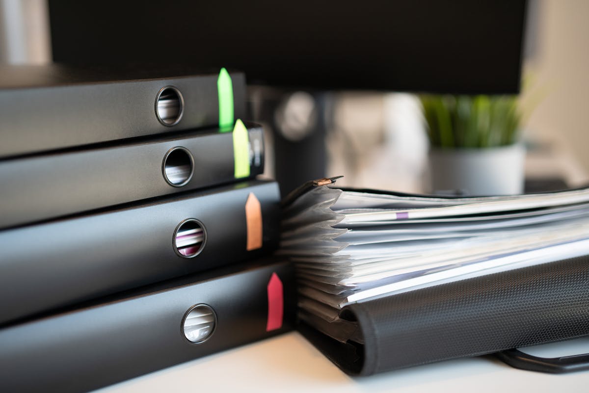 Ring binders full of documents on a desk.