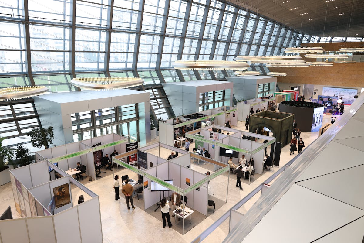 A bustling trade show inside a modern convention hall.