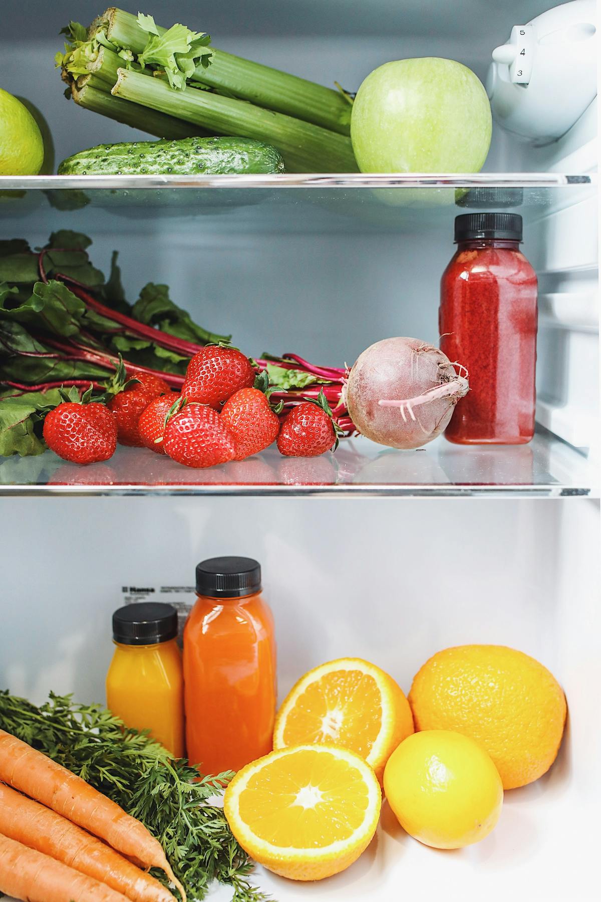 Vegetables and juices visible inside a fridge.