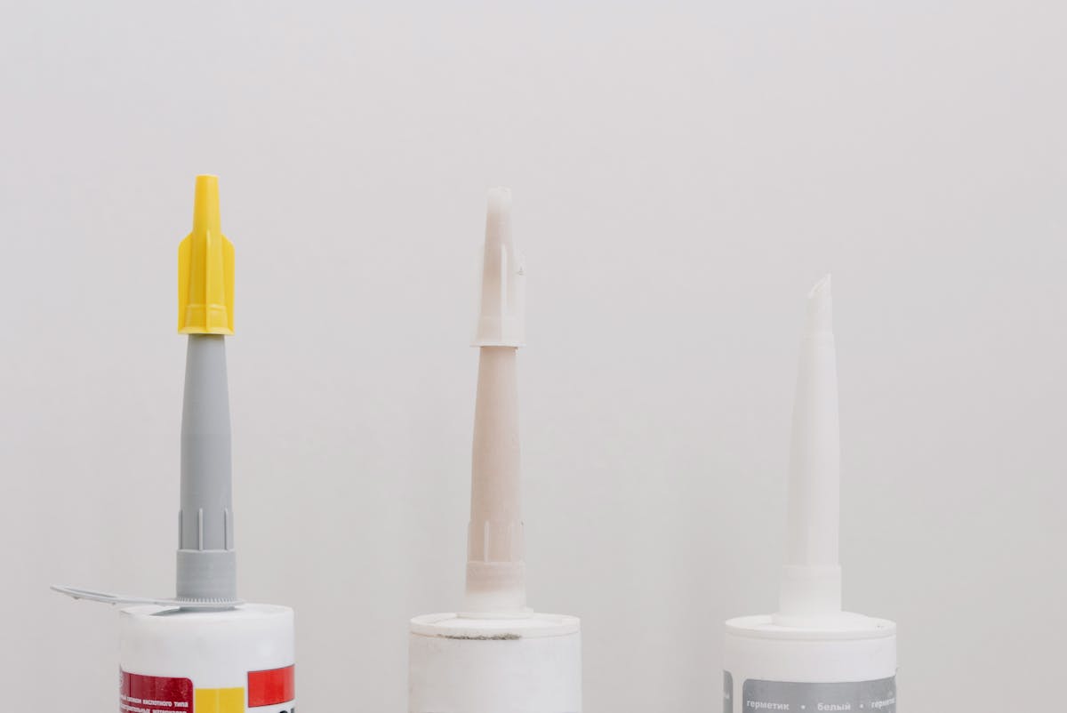Tubes of sealants and adhesives lined up in a workshop.