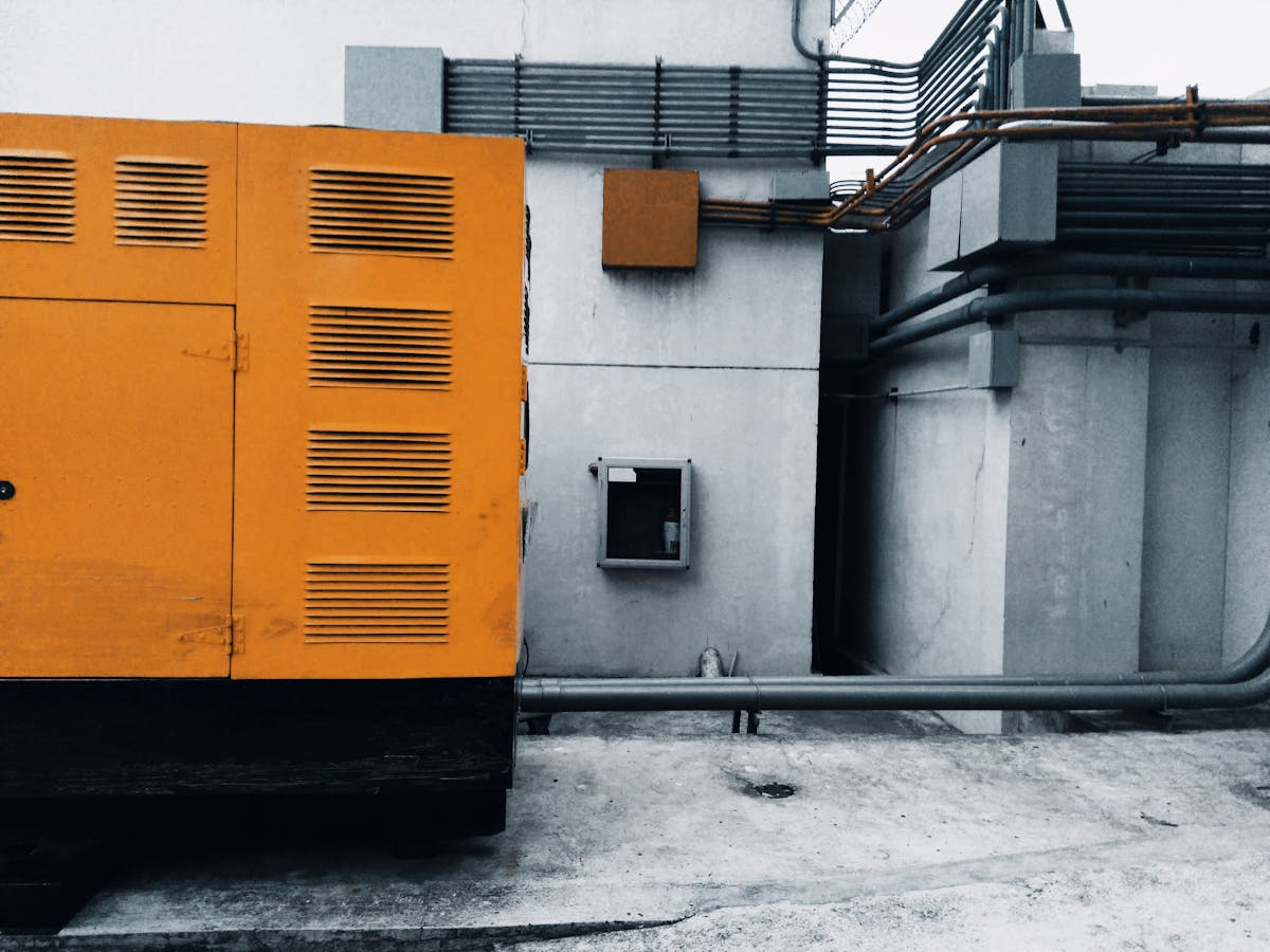 An outdoor industrial generator with visible piping and wiring.